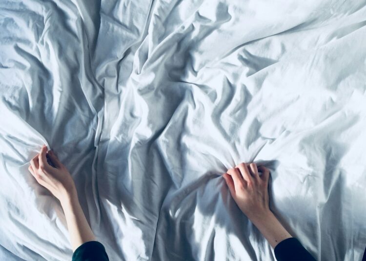 person holding white bedspread