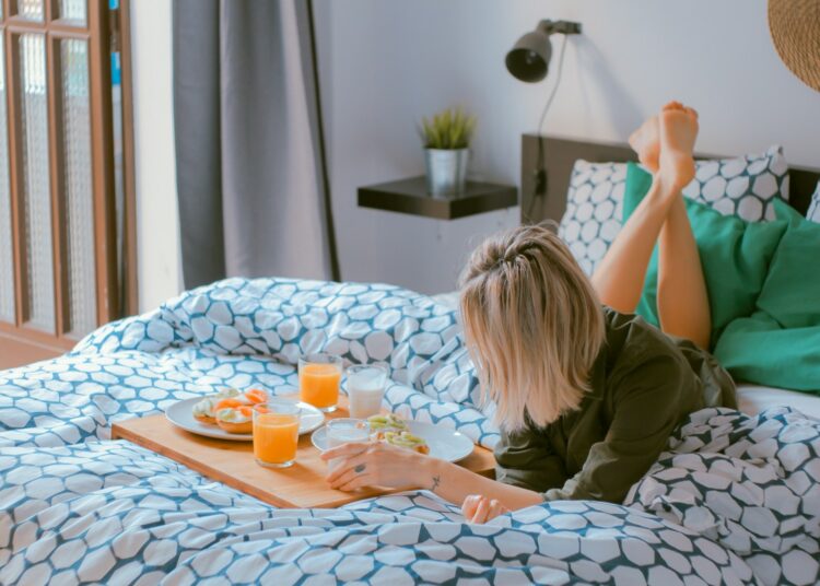 woman lying on bed white holding board