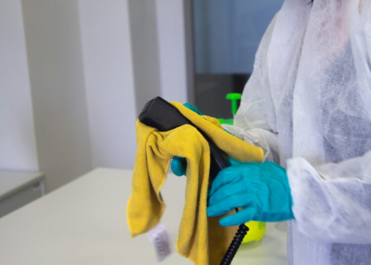 person in white robe holding black and yellow umbrella