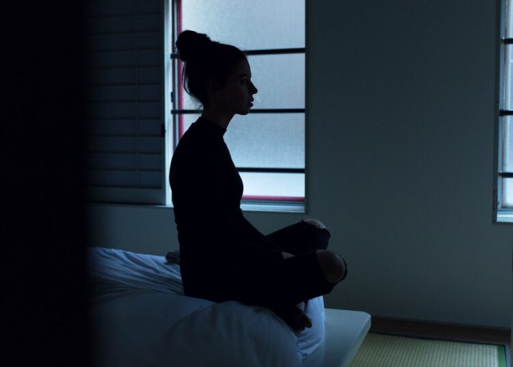 woman sitting on bed